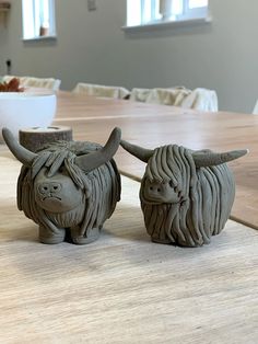 two ceramic bulls sitting on top of a wooden table