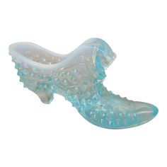 a glass shoe is sitting on a white surface