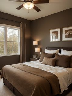 a bedroom with a bed, ceiling fan and two pictures on the wall above it