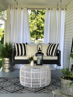 a white couch sitting on top of a black and white rug next to a window