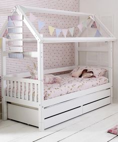 a white wooden bed with pink and blue decor