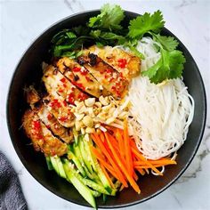 a bowl filled with meat and veggies on top of a marble countertop