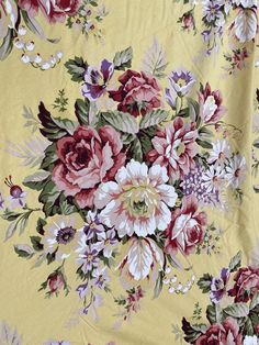 a yellow floral fabric with red, white and purple flowers on the bottom half of it