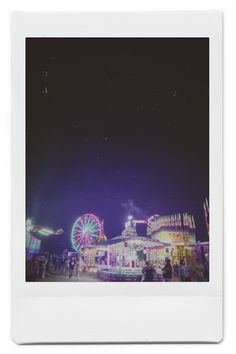 an amusement park at night with ferris wheel and rides