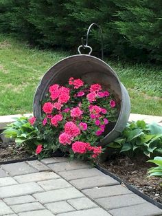 some pink flowers are in a bucket on the ground