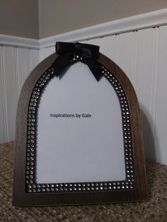 a wooden frame with a black bow on the top that says inspirations by dalee