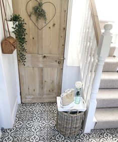 a door with a heart hanging on it next to a basket filled with flowers and plants