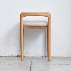 a wooden chair against a white wall