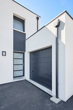 a white building with two garage doors and windows