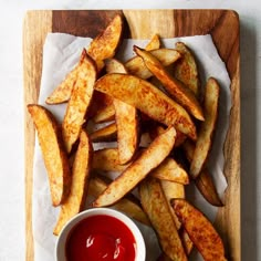 french fries with ketchup on a cutting board