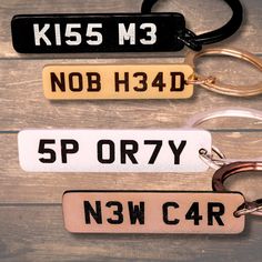 three key chains with different types of tags attached to them on a wooden surface,