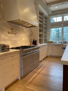 a large kitchen with white cabinets and stainless steel stove top oven, dishwasher, and sink