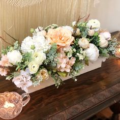 a vase filled with flowers sitting on top of a wooden table next to a candle