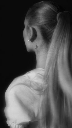 a woman with long hair and piercings on her ear