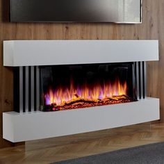 an electric fireplace with bright flames and wood paneling