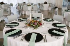 the table is set with black and white plates, green napkins, and silverware