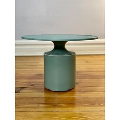 a green table sitting on top of a wooden floor