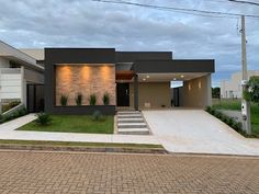 a modern house is shown in the evening with lights on it's front door