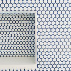 a blue and white wall with an open shelf in the middle that has circles on it