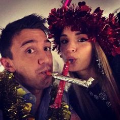 a man and woman with tinsel on their heads are posing for a selfie