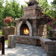 an outdoor fireplace in the middle of a patio