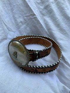 "You are looking at a genuine Mapalmex buckle measuring 4\"6 wide by 3\"8 high. Belt is made of tan leather and is luxuriously hand tooled with silver tone trim. Belt buckle is large with rodeo motif and leather belt is made by Chambers and is size 44 measuring 47\" long. Buckle is silver plate made in Mexico. I want to stress that item is vintage which means it's not new. All my customers are very important to me and I believe communication is very important. I do not sell or encourage any one Rustic Belt With Antique Buckle For Western Events, Rustic Hand Tooled Belt Buckles For Western Events, Rustic Concho Belts For Rodeo, Western Style Engraved Belt For Ranch, Southwestern Style Belt Buckle With Belt For Rodeo, Western Belts And Suspenders With Antique Buckle For Ranch, Western Style Adjustable Belts And Suspenders With Concho, Brown Hand Tooled Belt Buckles For Rodeo, Western Style Belts And Suspenders With Concho