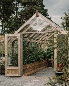 a wooden greenhouse with plants growing inside