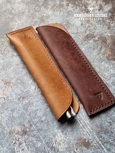 a brown leather sheath for a knife on top of a stone floor with the handle open