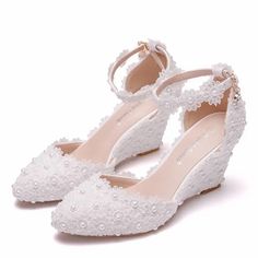 a pair of white shoes with pearls on the toes and heels, all in lace