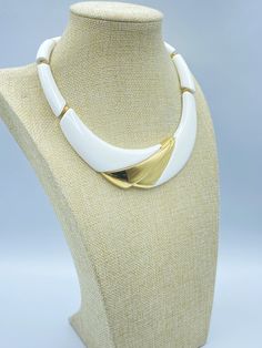 A Vintage Napier White and Gold Necklace. This is the 1988 Napier is Brainier ad necklace in white hard resin with gold tone accents. The choker is 17 inches long. Along with the gold tone accents on the pendant there curved tube beads and gold tone flat spacer beads. This Napier choker has a spring ring clasp with a metal hang tag signed Napier©. The length of the curved pendant is 6 (inside) and 8 (outside) inches. The width of the pendant is 1 3/8 inches at its widest. This Napier white and gold pendant choker has a substantial weight of 2.96 ounces. Minor surface scratching is visible under a loupe but not to the unaided eye.  This piece is in excellent condition. Add this 80s Napier necklace to your Napier jewelry collection! Please see the photos and don't hesitate to contact me to a Retro White Jewelry For Anniversary, Vintage White Necklace For Anniversary, White Retro Jewelry For Anniversary, Napier Jewelry, Pendant Choker, Tube Beads, Spacer Beads, Spring Rings, Gold Pendant