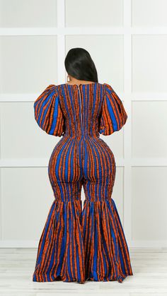 Make a bold fashion statement in this African print jumpsuit. The bell-bottom silhouette is a stylish way to show off your curves and add a touch of flair to any look. Crafted from a soft and stretchy material, this jumpsuit is perfect for any occasion. The vivid pattern features tribal style designs that add a unique and stylish touch to the look. Wear this vibrant piece with a pair of heels, and have an outfit that looks great all day long. This jumpsuit is made of 100% African cotton and is e Chic Fitted Flare Jumpsuits And Rompers, Spring Flare Fitted Jumpsuits And Rompers, Orange Fitted Chic Jumpsuits And Rompers, Chic Orange Fitted Jumpsuits And Rompers, Chic Fitted Multicolor Jumpsuits And Rompers, Cultural Day Outfits, African Jumpsuits For Women, Ankara Jumpsuit Styles, African Jumpsuit