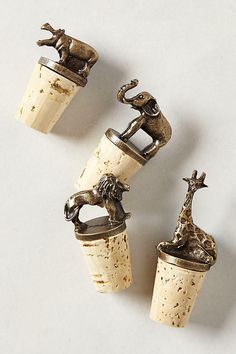 three wine corks with animal figurines on them sitting next to each other