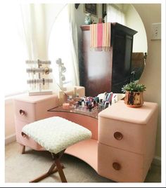 a pink vanity with a mirror and stool