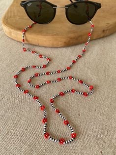 a pair of sunglasses sitting on top of a table next to a beaded necklace