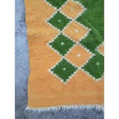 an orange and green area rug on the floor