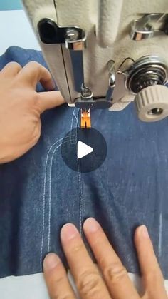 someone is using a sewing machine to sew something on the jeans that they are wearing