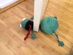 there is a crocheted bag on the floor next to a wall and door