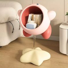 a pink and white object on a stand in a living room next to a couch