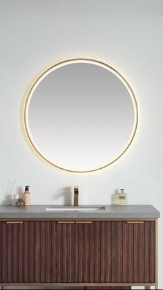 a bathroom vanity with a round mirror above it