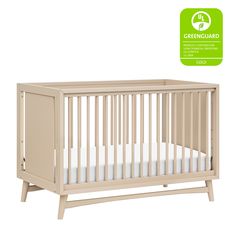 a baby crib with the greenguard logo above it