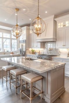 a kitchen with marble counter tops and stools in front of an island that has three lights hanging from it