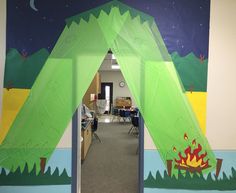 an open door to a classroom with a tent on the wall and campfire painted on it