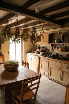 a wooden table sitting in a kitchen next to a potted plant on top of a counter