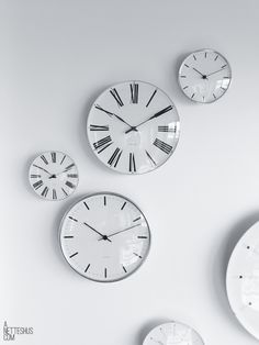 three clocks are hanging on the wall with different times in each one's face