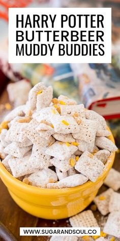 a yellow bowl filled with muddy buddies on top of a wooden table next to crackers