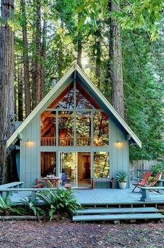 a small cabin in the woods surrounded by trees