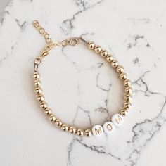 Made of high quality 14k gold filled beads, the NEW Luxe Gold Filled Mom Bracelet makes the sweetest gift or treat for yourself. Great on its own or paired with a watch — always amazing layered. One beaded bracelet Size: 6” + 1.5” gold filled extender 5mm high quality 14k gold filled beads Lobster clasp Does not turn, tarnish, or rust Handmade with the highest standards & quality materials Includes 100% organic cotton jewelry pouch This item is made to order and shipped with love from our studio Adjustable Rose Gold Beaded Bracelets In 14k Gold, Gold Name Bracelet With Letter Beads, Beaded 14k Gold Filled Yellow Gold Bracelets, Adjustable Gold Beaded Bracelets As Gift, Everyday 14k Gold-filled Bracelets With Gold Beads, Everyday Bracelets With 14k Gold Beads, Personalized Adjustable 14k Gold Bracelets, Rose Gold Beaded Bracelet In 14k Gold Filled, 14k Gold Bracelet With Gold Beads As Gift