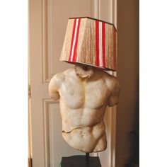 a statue with a lamp on top of it's head in front of a door