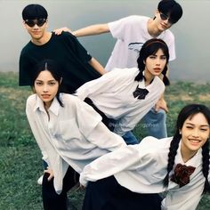 four young people posing for a photo in the grass