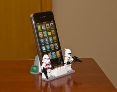 a lego star wars stormtrooper and storm trooper cell phone holder on a table